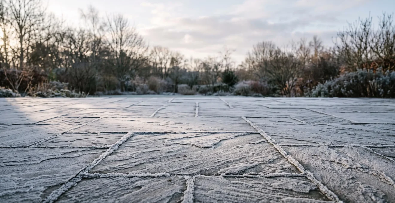 Terrasse en dallage de pierre naturelle recouverte de givre matinal en hiver, illustrant la resistance au gel